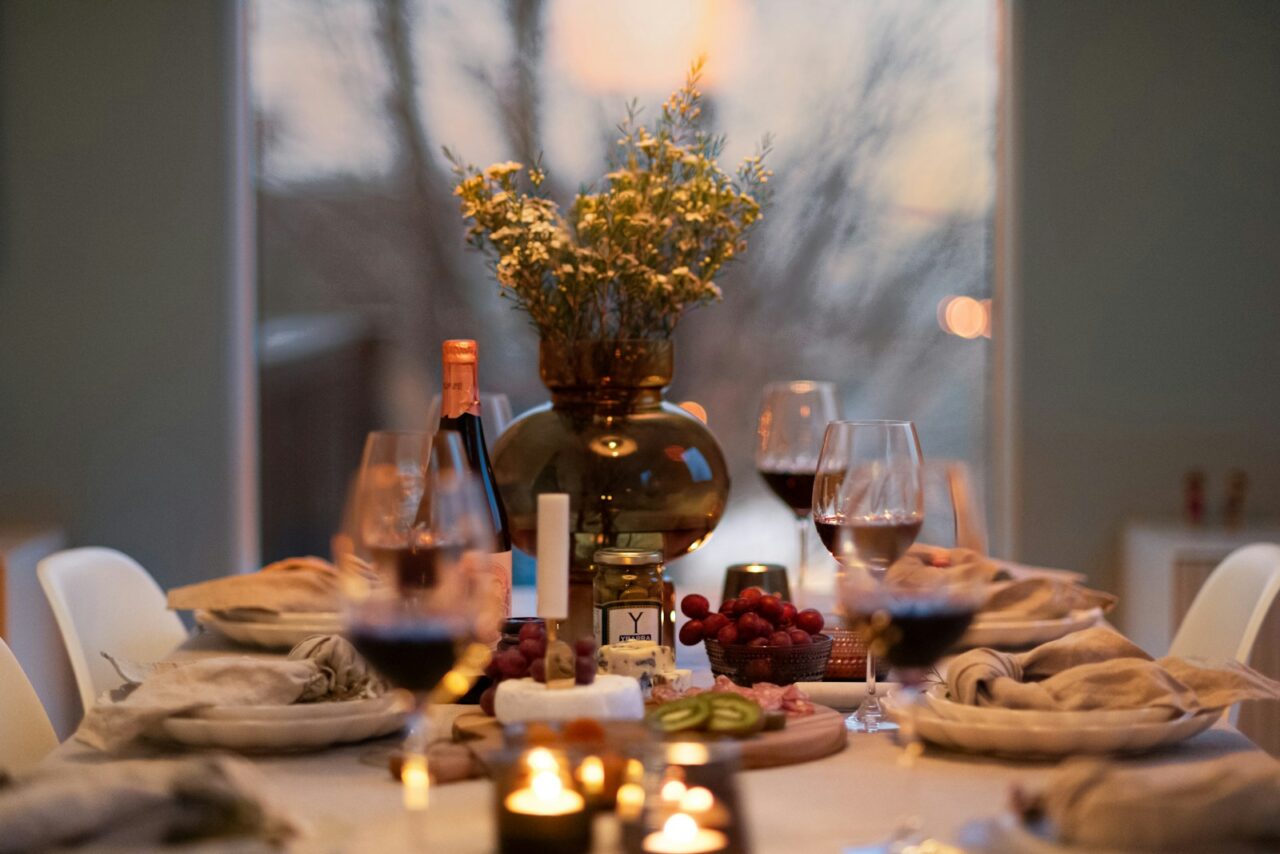 A dinner table with wine glasses and plates of food