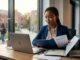 A Nigerian student reviews admission papers beside a laptop at a modern desk.